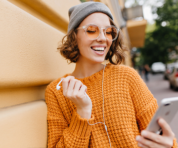 Woman with mobile phone and headphones smiling